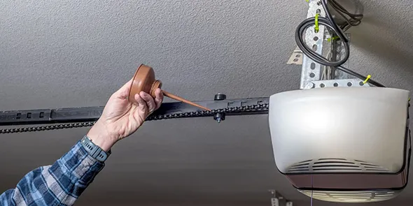 A technician working on a garage door motor, demonstrating repair services.