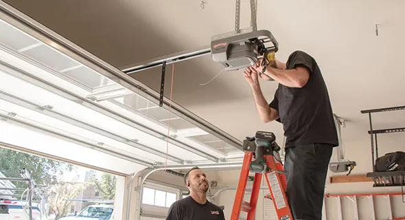 Two technicians working on a garage door motor installation, with text about fast garage door installation services in New Braunfels, TX.