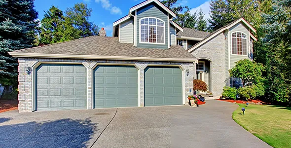 A residential house with a triple garage door, featuring a clean and modern exterior.